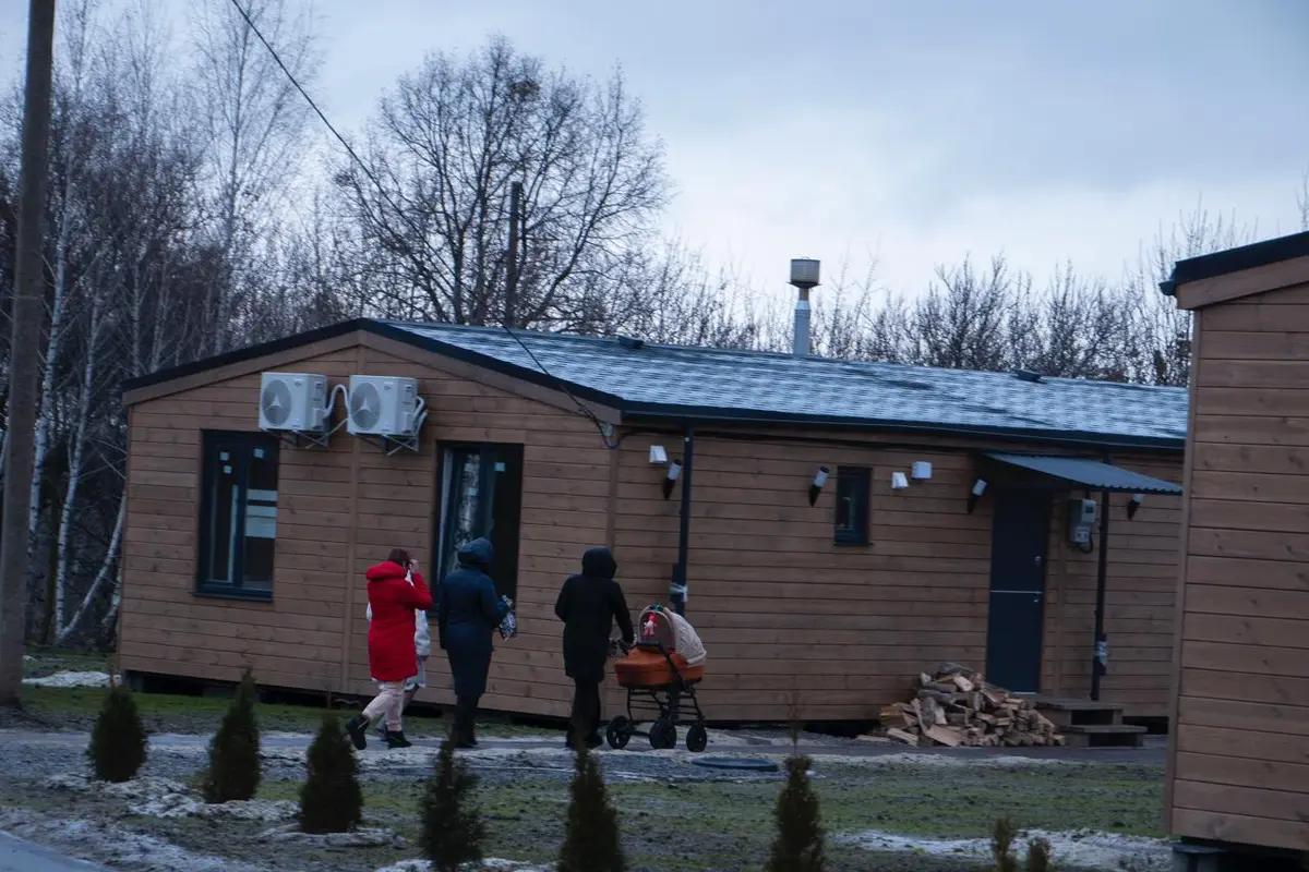 Родини з дітьми прямують до модульного будинку в містечку Q-tochok